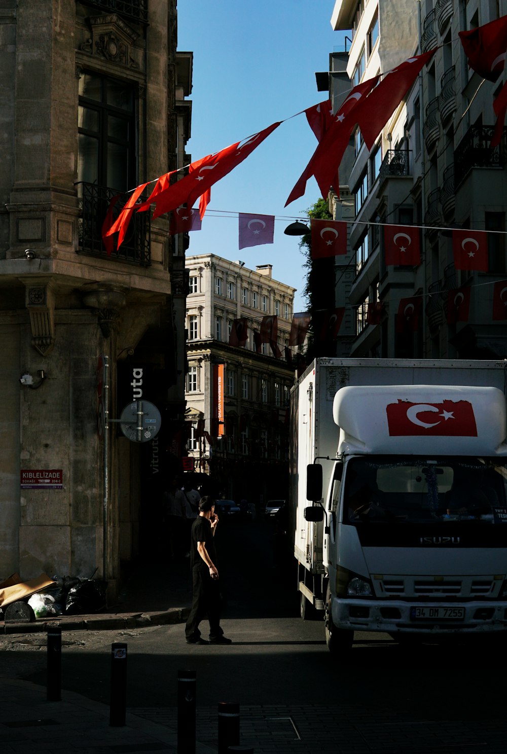 a man walking down a street next to a truck