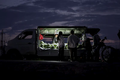 A refrigerated truck transporting fresh produce on a highway at sunset.