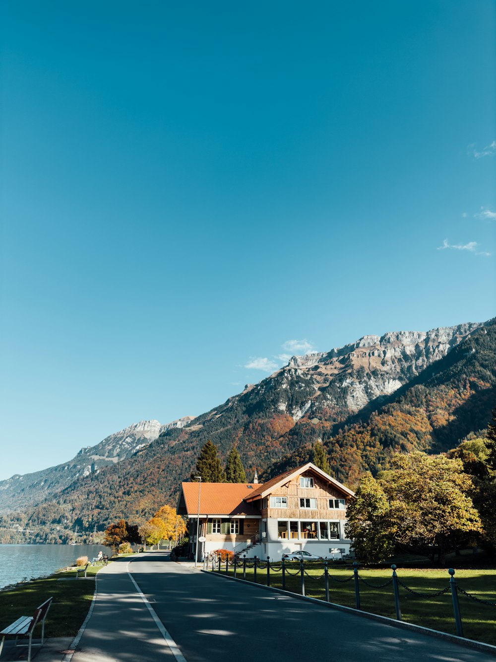 a house sitting on the side of a road next to a lake