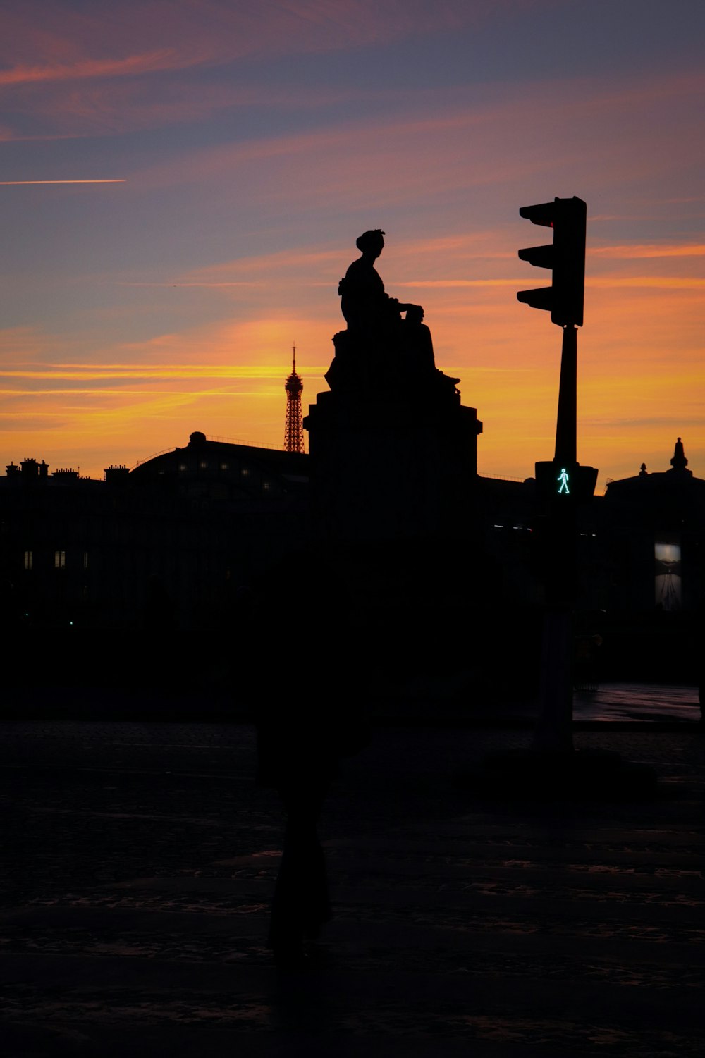 a silhouette of a building and a traffic light