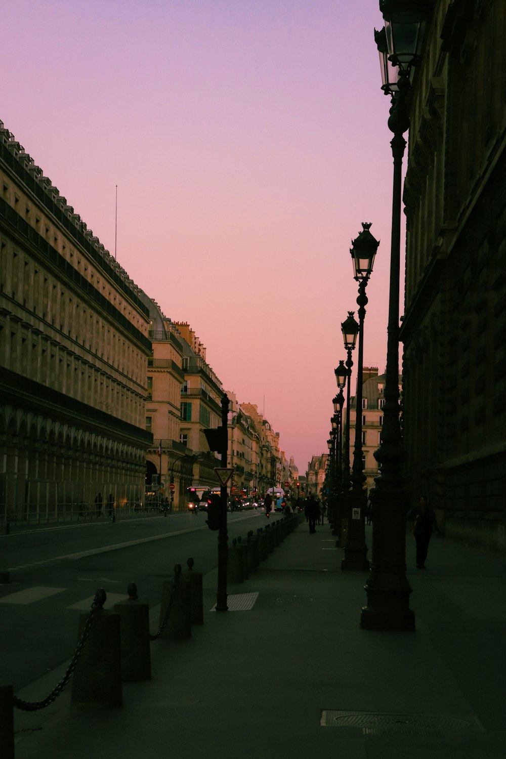 a city street at dusk with a street light on the side of the street