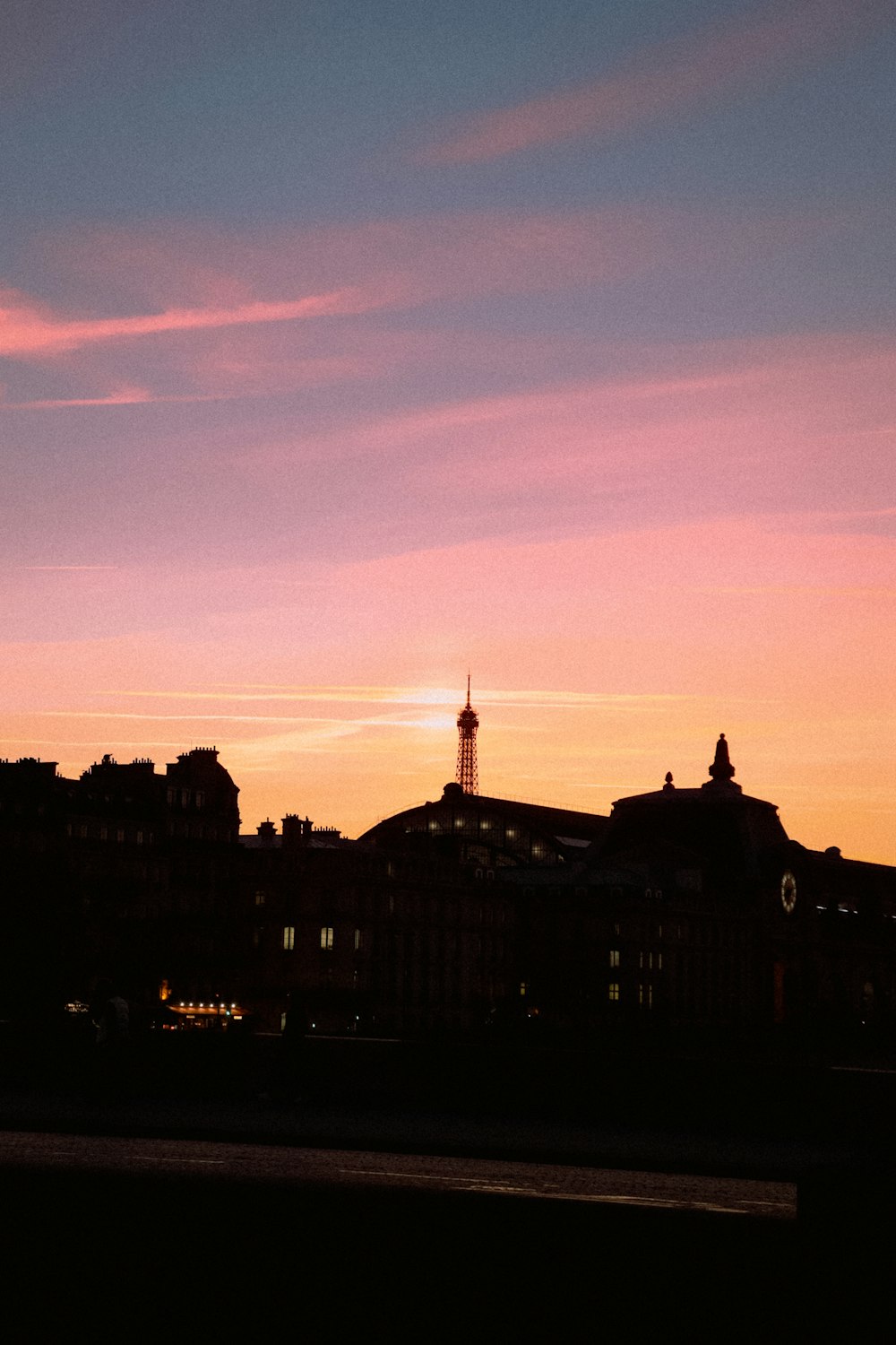 Una vista del tramonto di una città con una torre dell'orologio in lontananza
