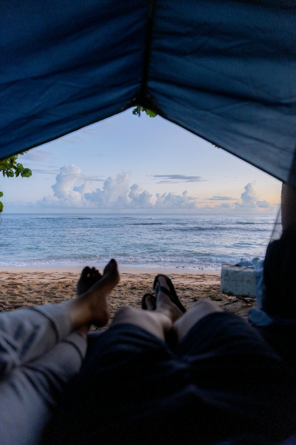 a person laying in a tent on the beach