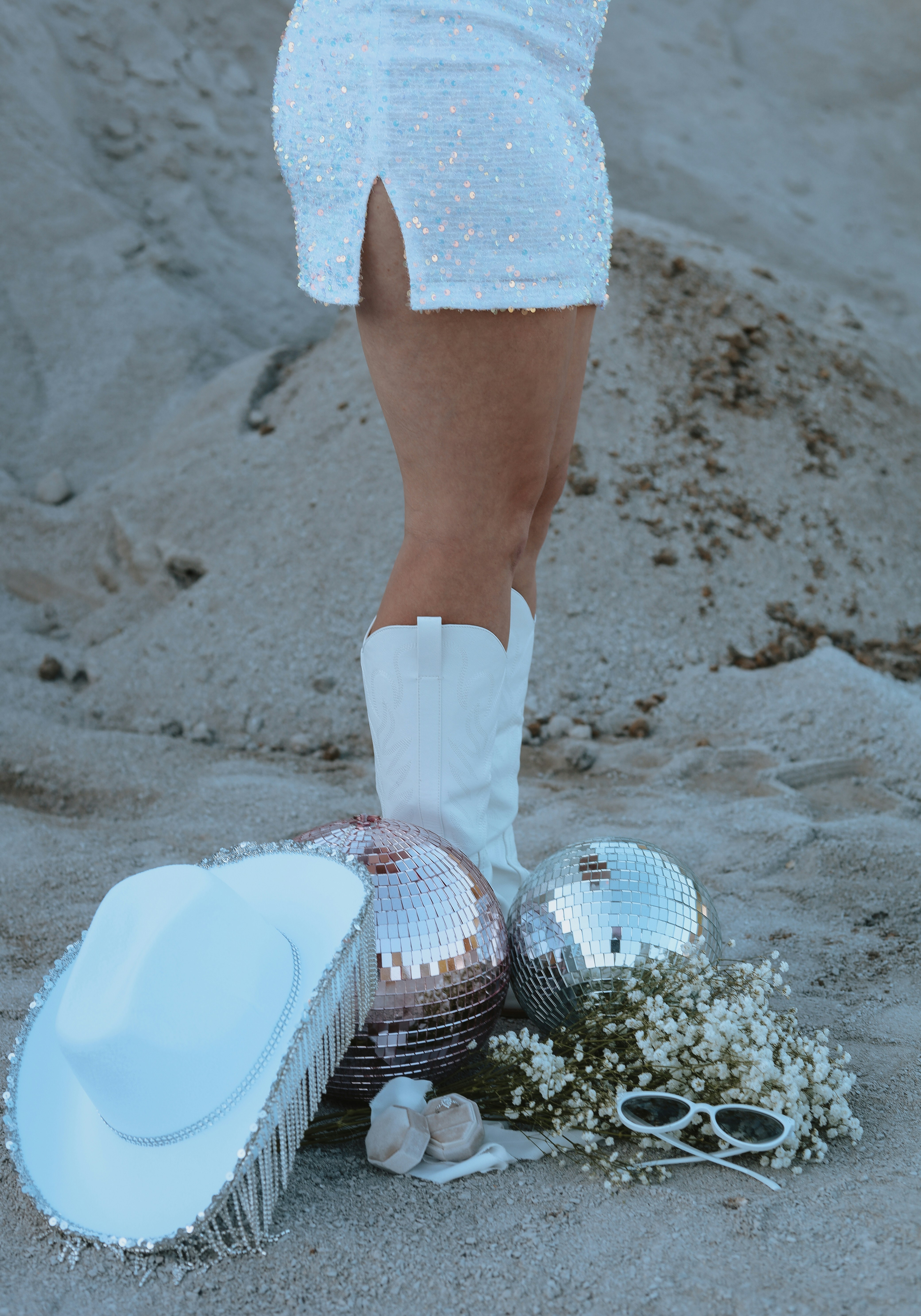 ビーチの白いカウボーイブーツと帽子