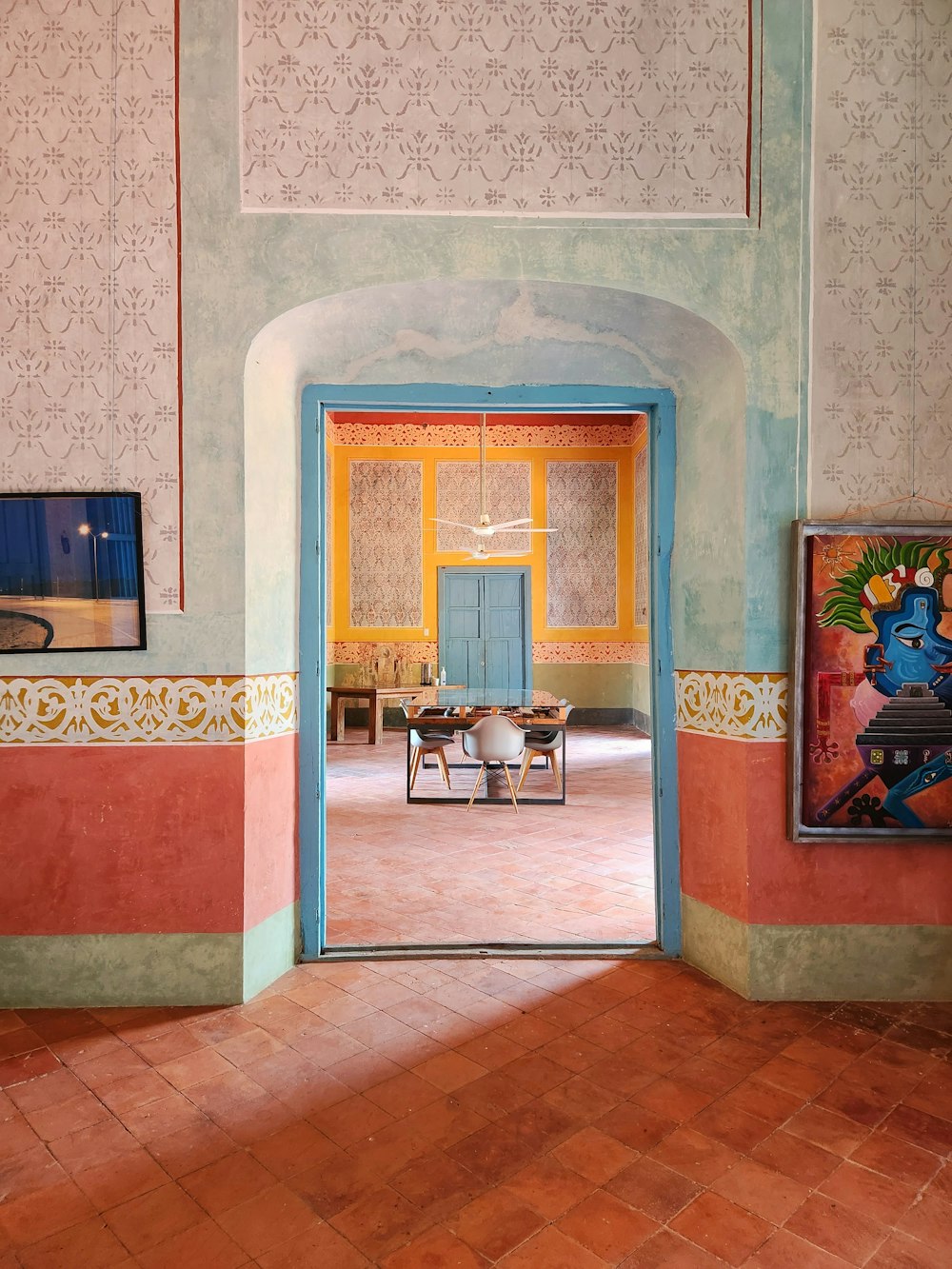 una habitación con una puerta azul y una pintura en la pared
