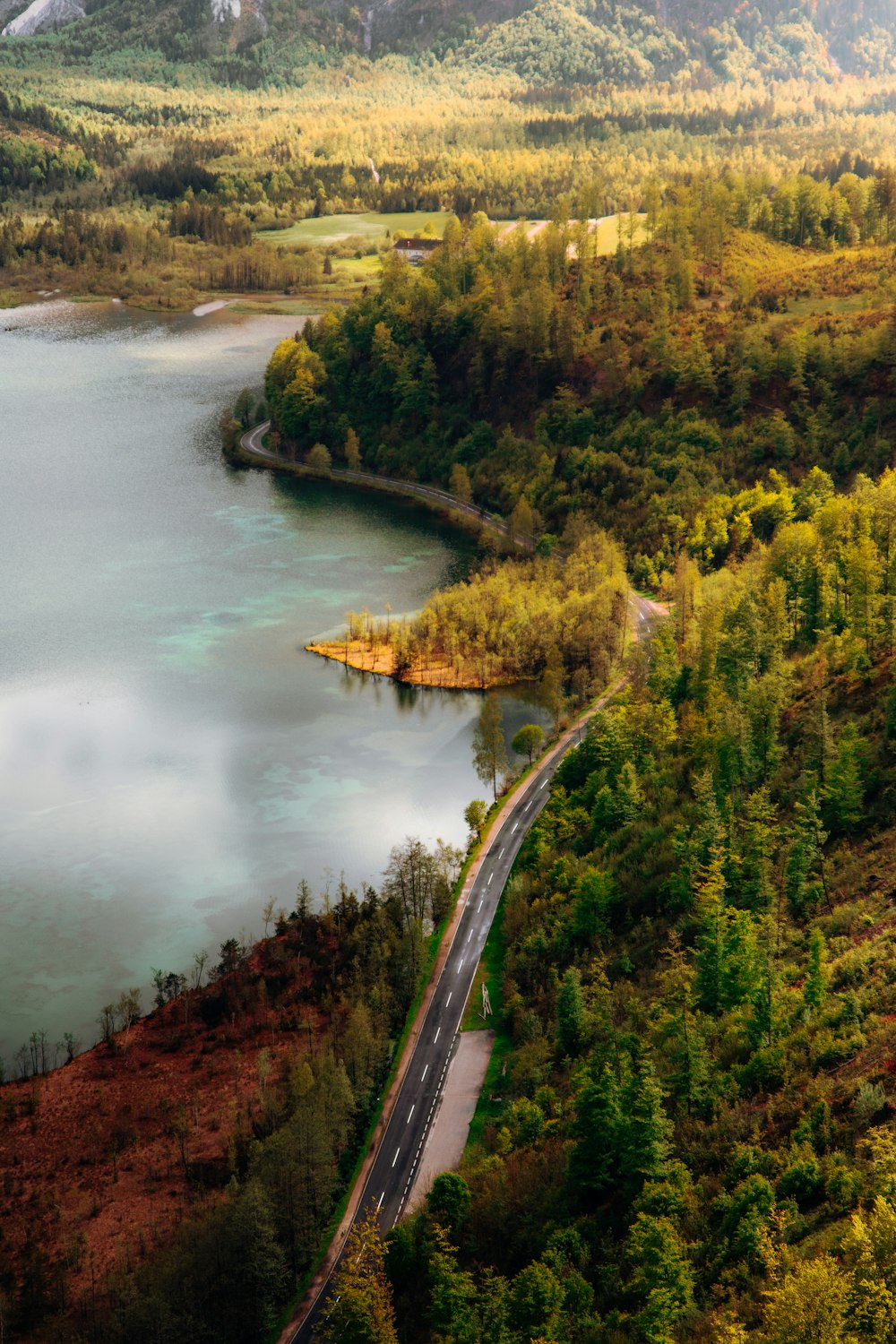 an aerial view of a road near a lake