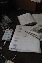 a bunch of papers and a cell phone on a table