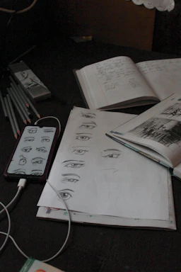 A cozy workspace with sketchbooks, pens, and a laptop open to a comic storyboard.