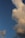 A large, fluffy cloud dominates the right side of the image against a backdrop of clear blue sky. The cloud appears illuminated by warm sunlight, creating a contrast between the vibrant sky and the soft, textured cloud.