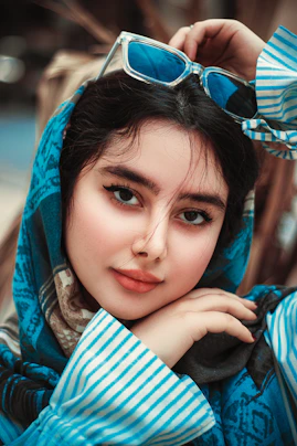 a woman wearing a blue scarf and sunglasses