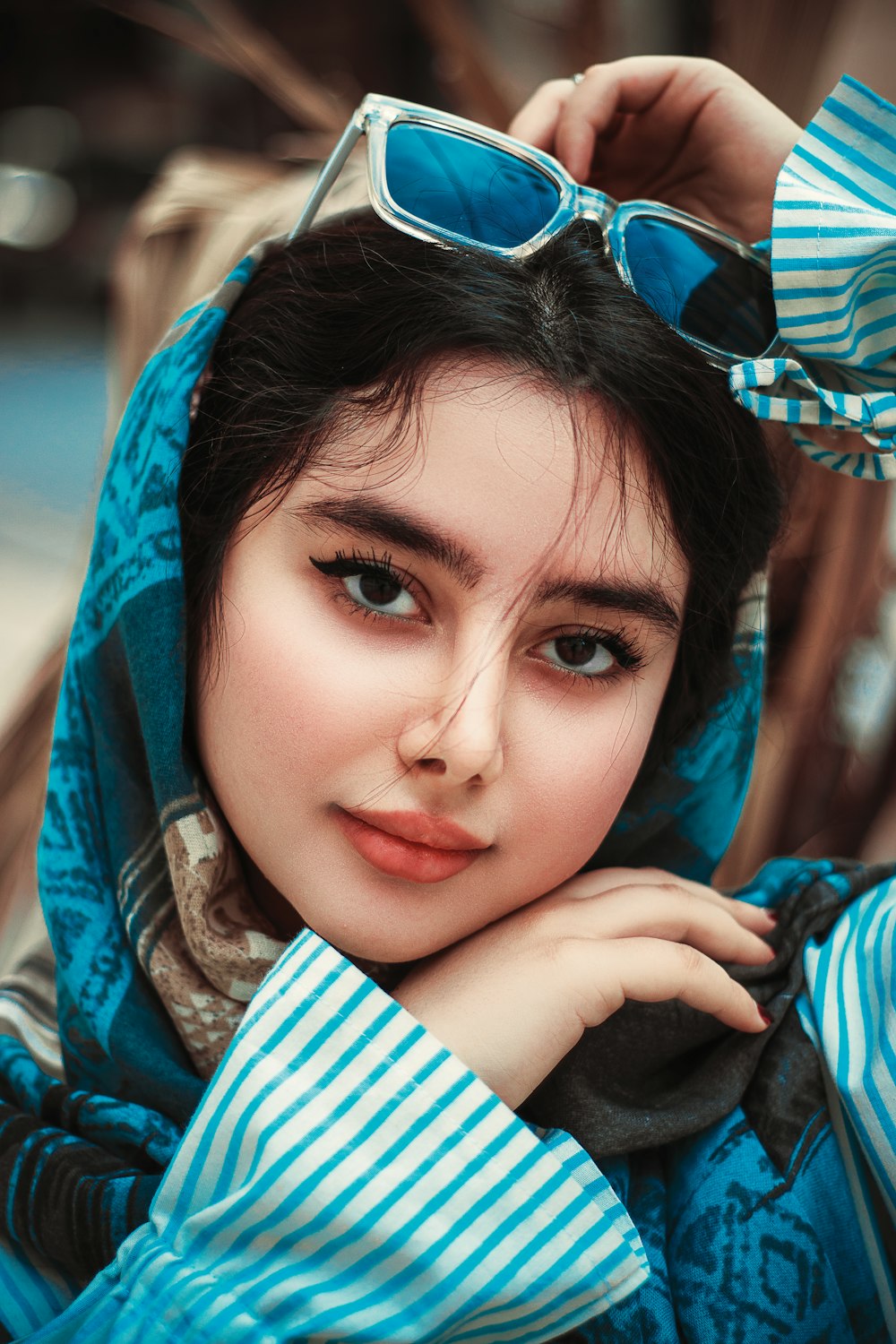 a woman wearing a blue scarf and sunglasses