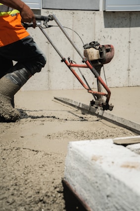 a man using a machine to pour concrete