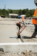 a man in an orange safety vest is working on a road