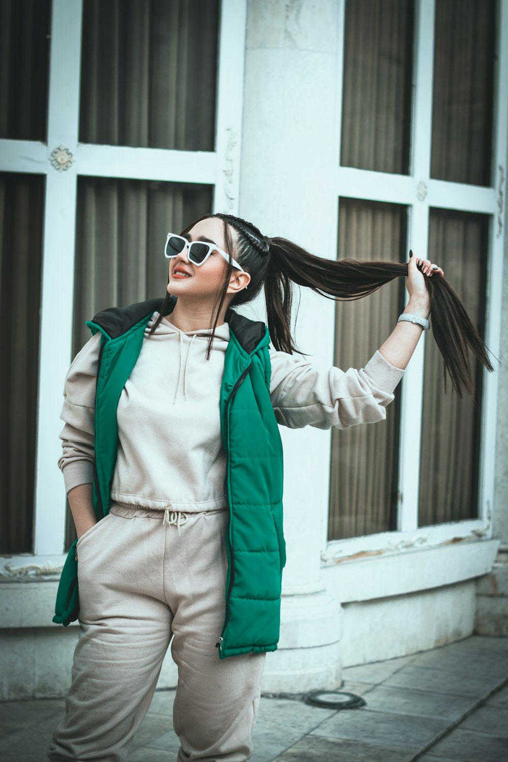 a woman with sunglasses and a green vest