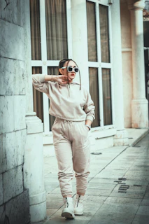 A casual street style shot of a model sporting Sporiva's modern tracksuit while leaning against a graffiti wall.
