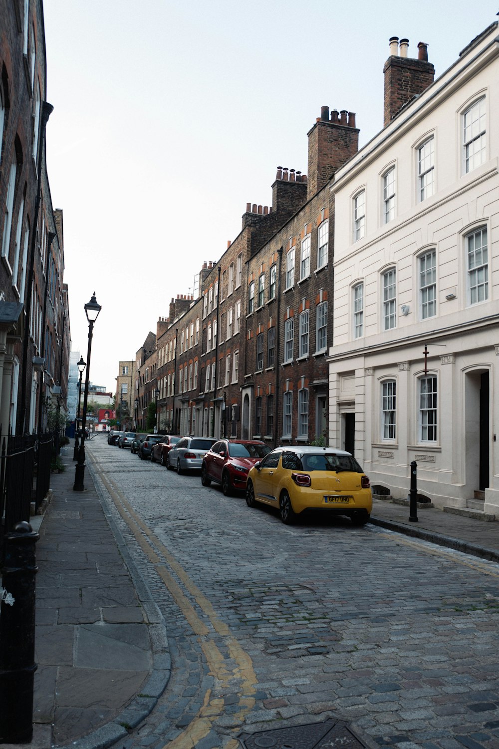 a row of parked cars sitting on the side of a street