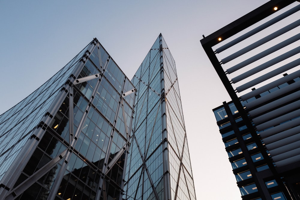 a very tall glass building next to another tall building