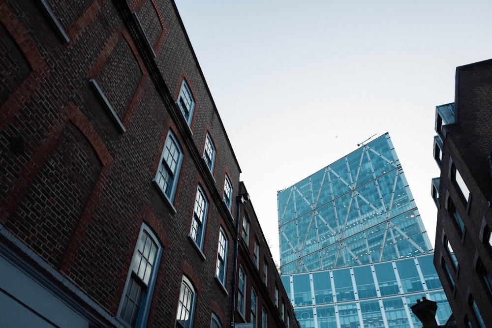a tall brick building next to a tall glass building