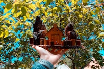 Close-up of hands holding a model house symbolizing trust and investment.