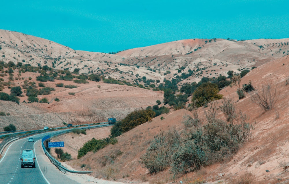 a car driving down a road in the mountains