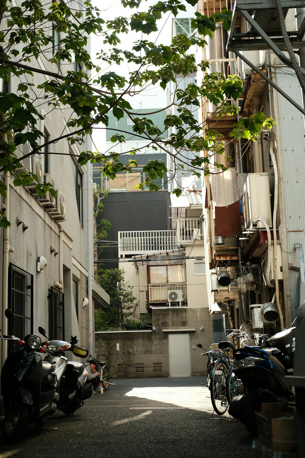 a narrow alley way with parked motorcycles and buildings