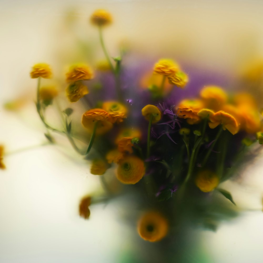 a vase filled with yellow and purple flowers