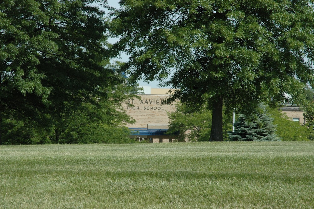 a field with trees and a building in the background
