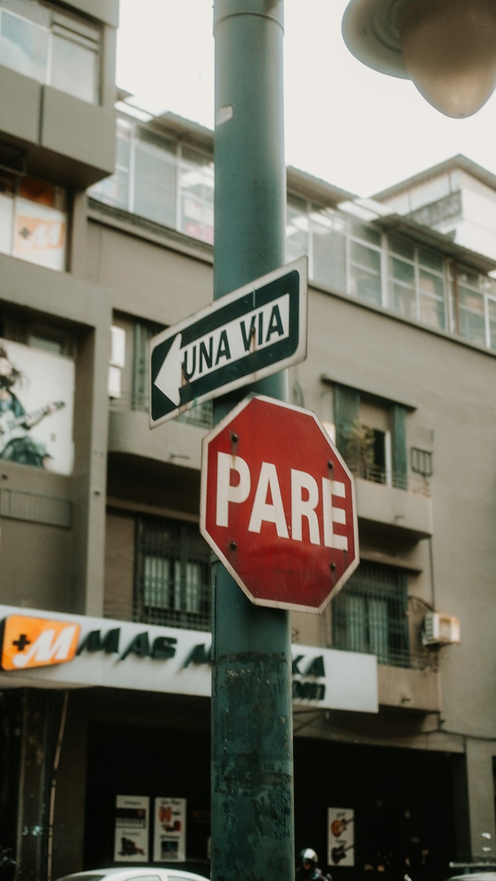 a red stop sign sitting on the side of a green pole