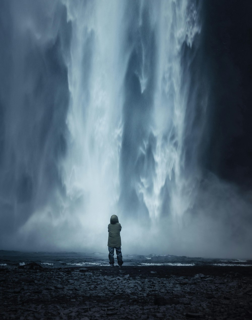 a person standing in front of a huge storm