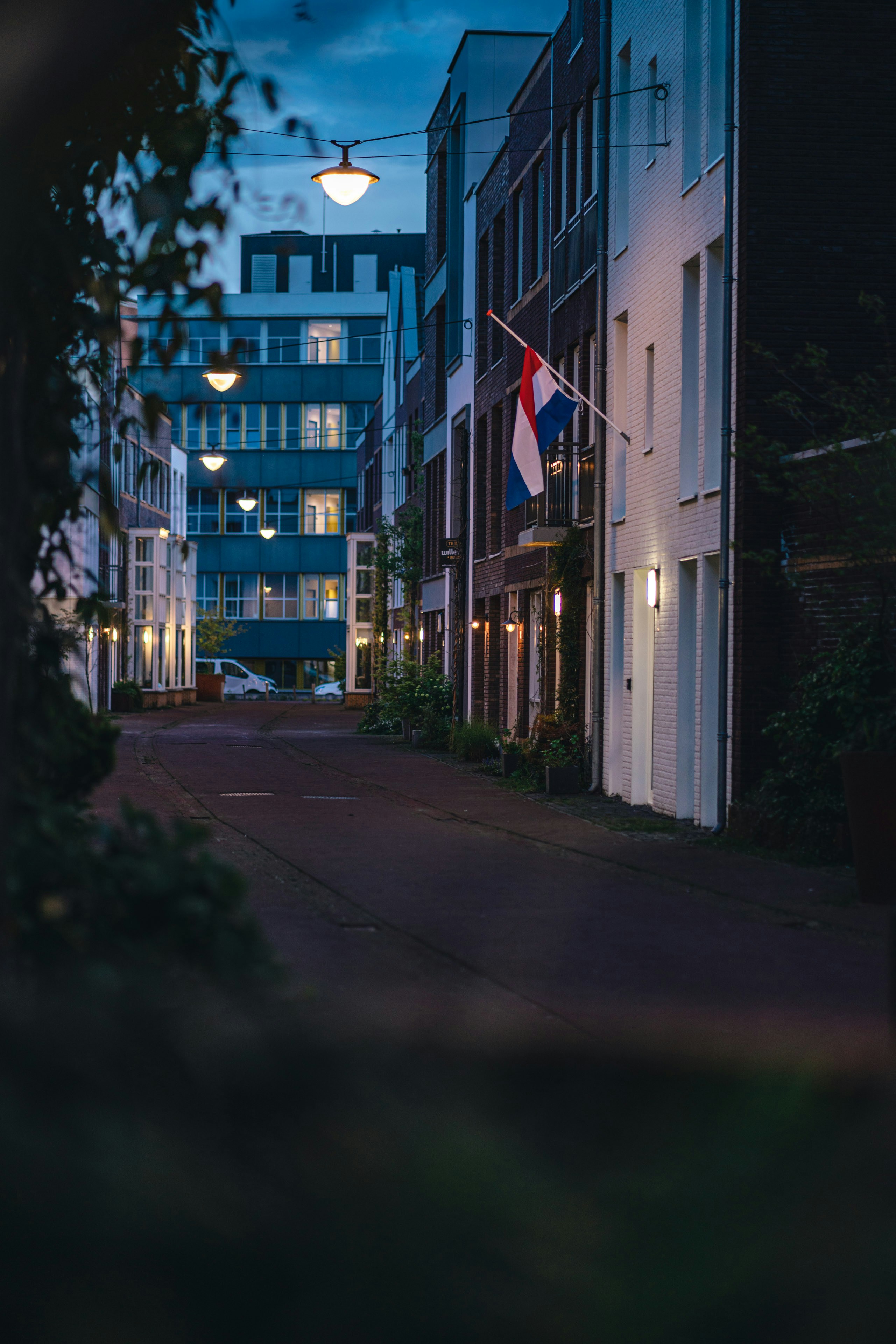 a city street at night with a flag on the building
