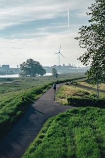 a person walking down a path near a wind turbine