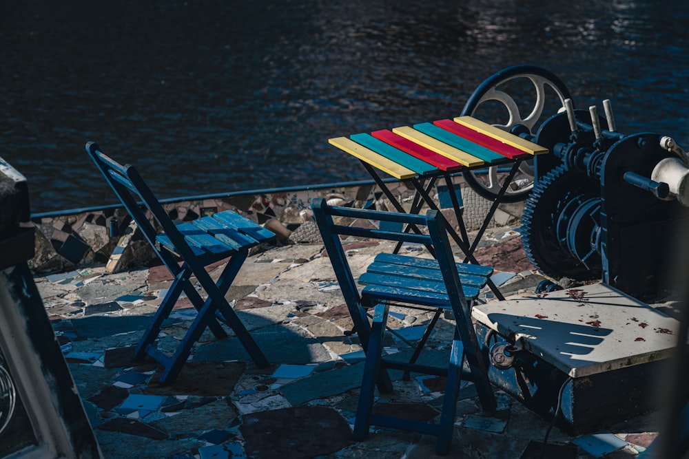 a row of chairs sitting next to a body of water