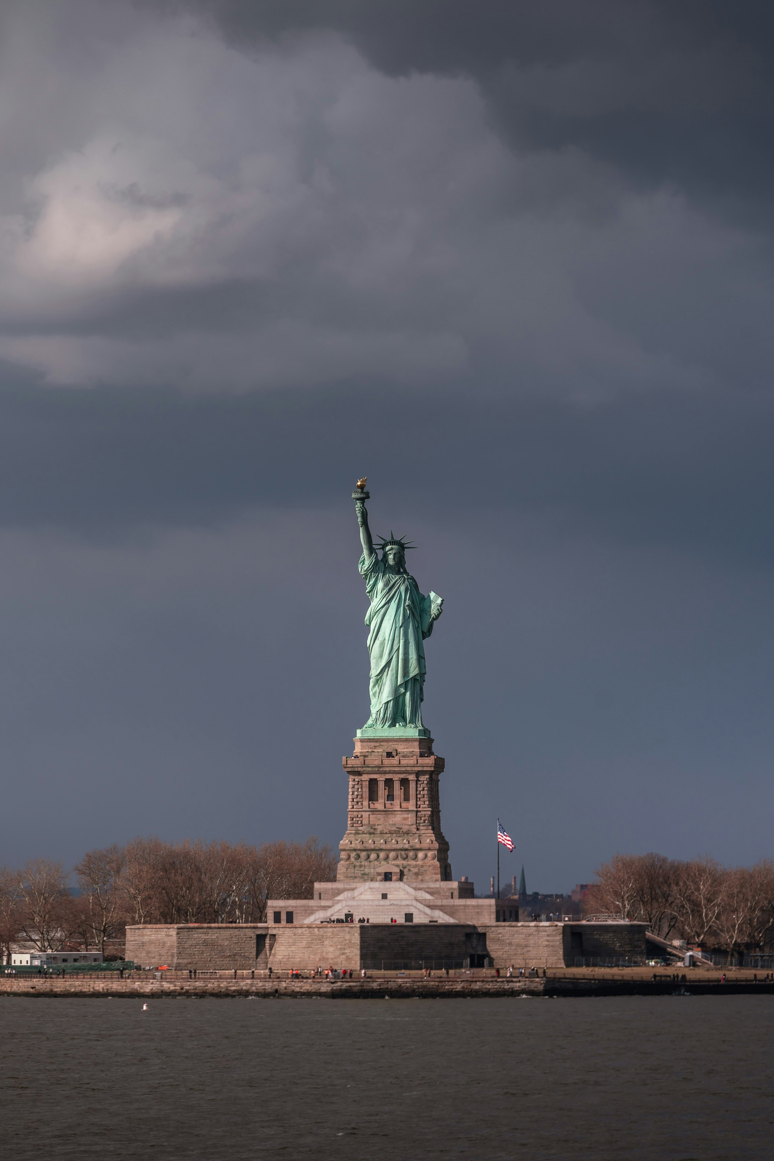 the statue of liberty stands in the middle of a body of water