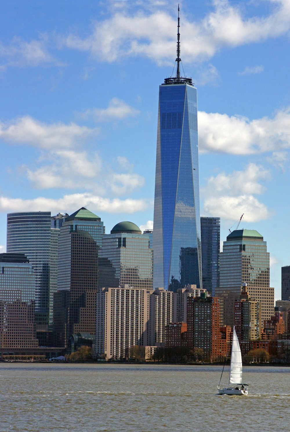 a sailboat in a body of water in front of a large city