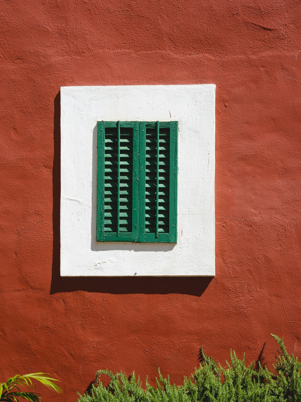 a red and white building with a green window