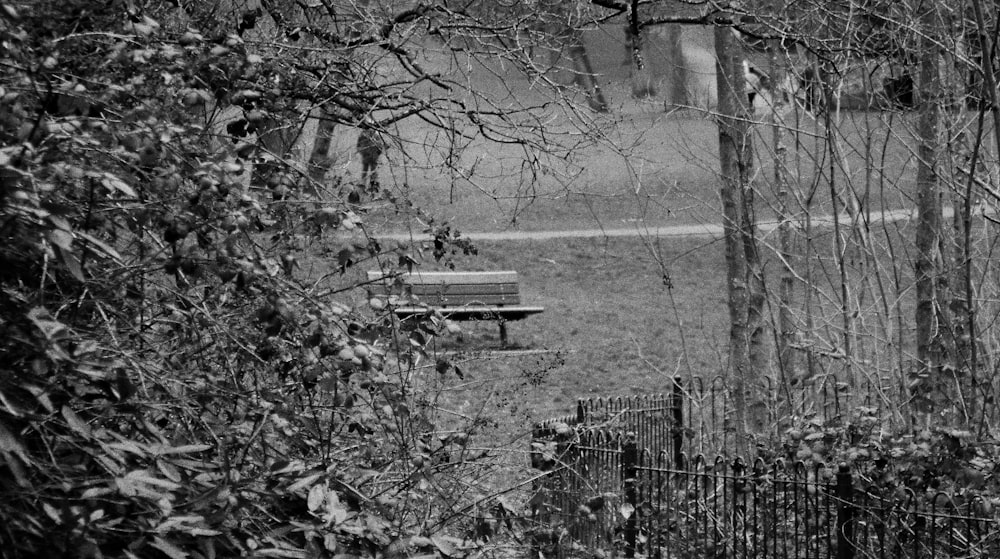 a black and white photo of a park bench