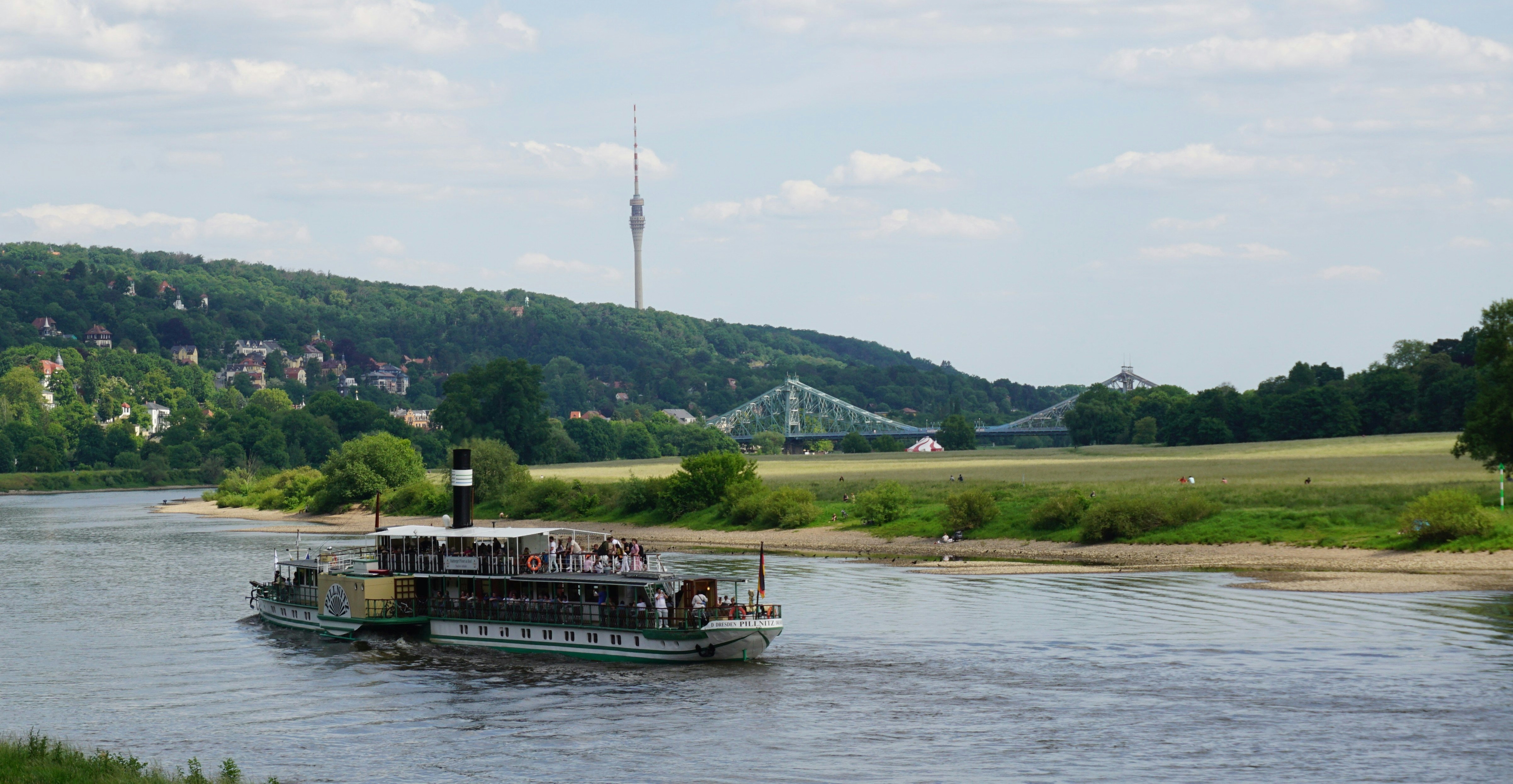 A steamboat on the Elbe river in Dresden is heading towards the bridge "Blaues Wunder".