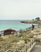 a wooden walkway leading to a beach next to the ocean