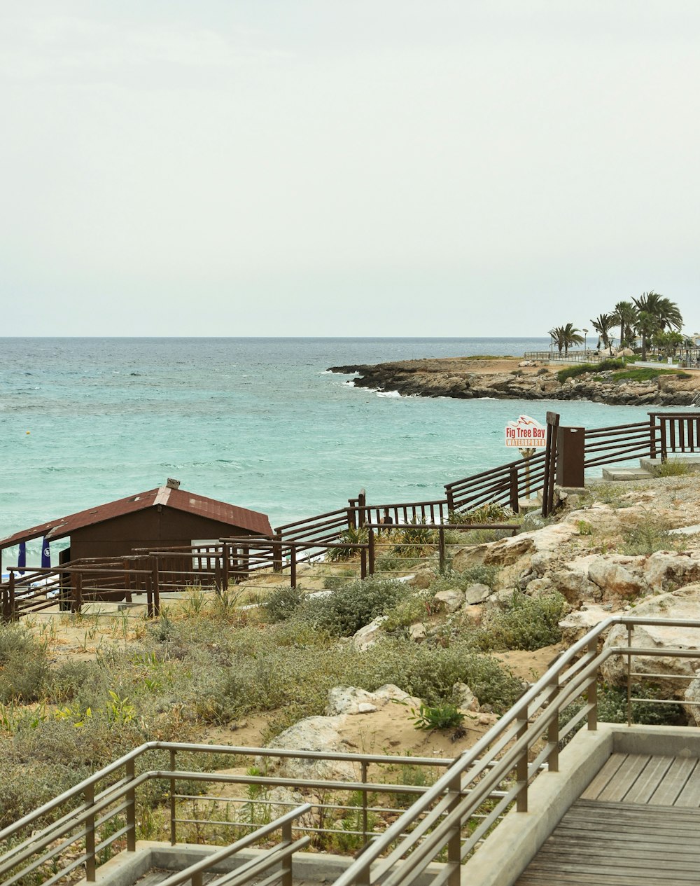 a wooden walkway leading to a beach next to the ocean