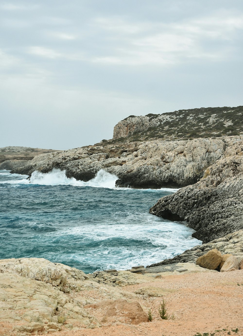 a large body of water sitting next to a rocky shore