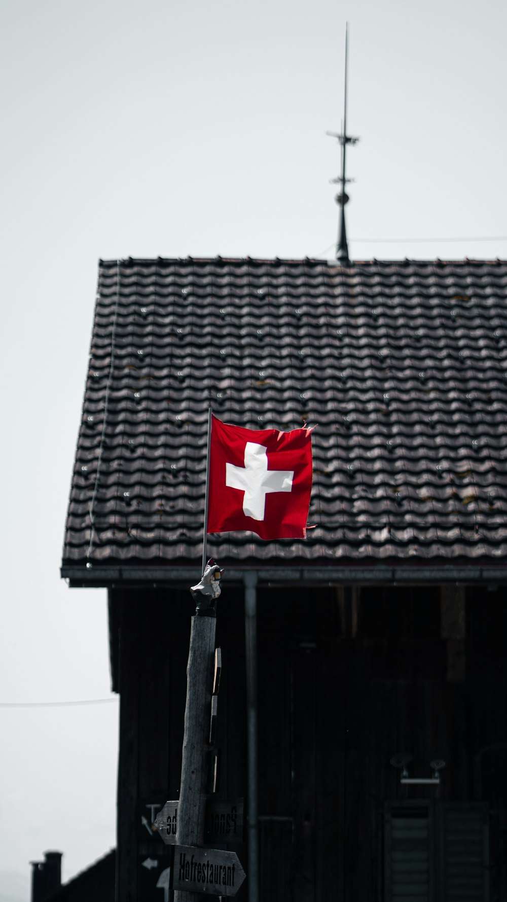 a swiss flag on a pole in front of a building