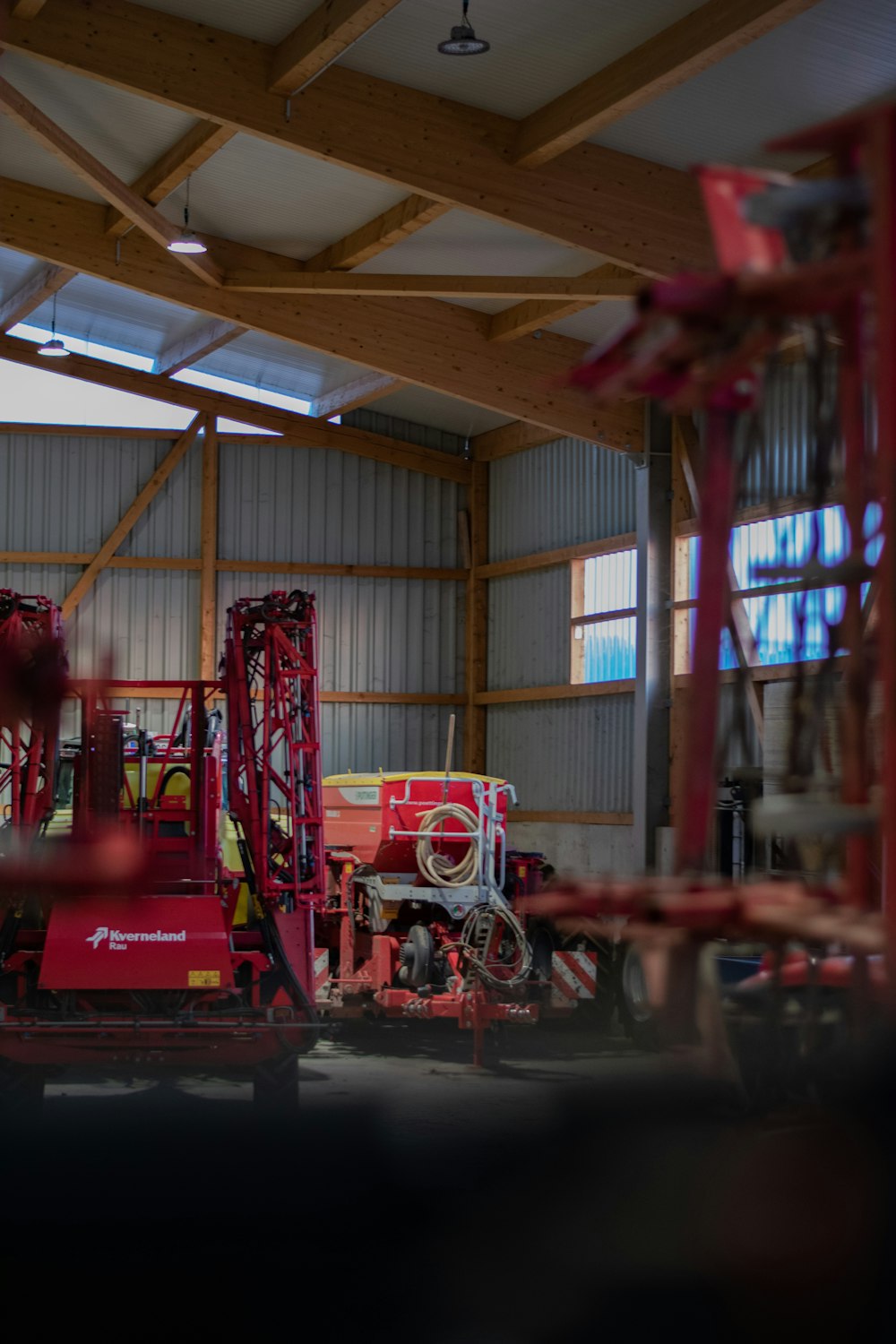 a large red machine in a building with wooden beams