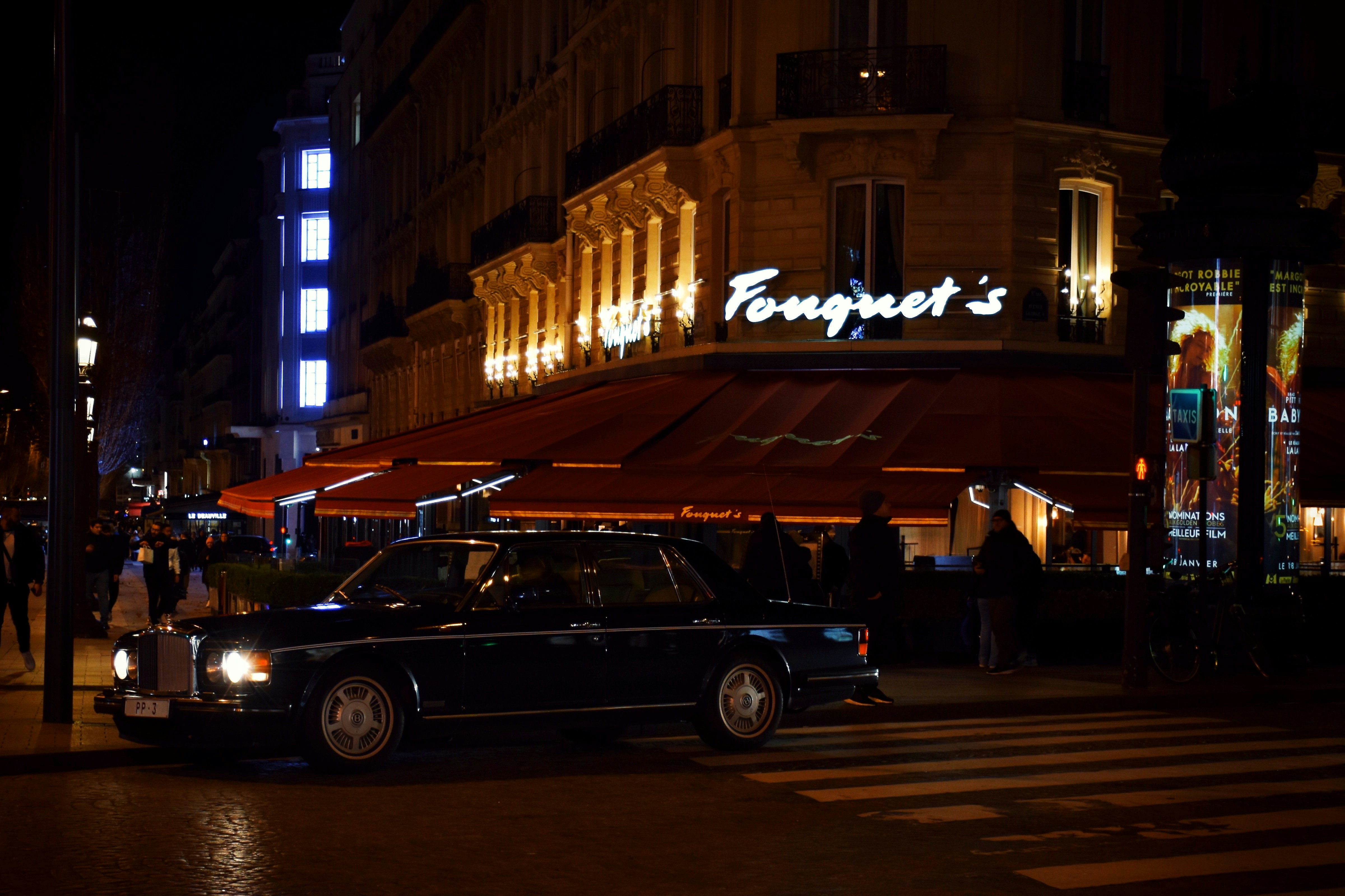 a car parked on the side of a street at night