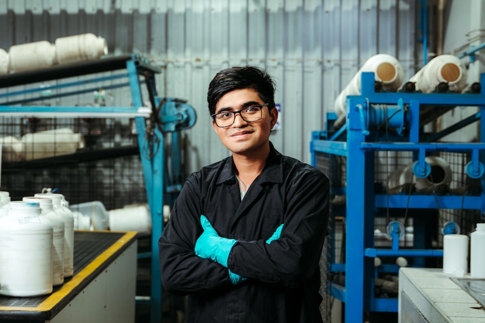 a man standing in a factory with his arms crossed