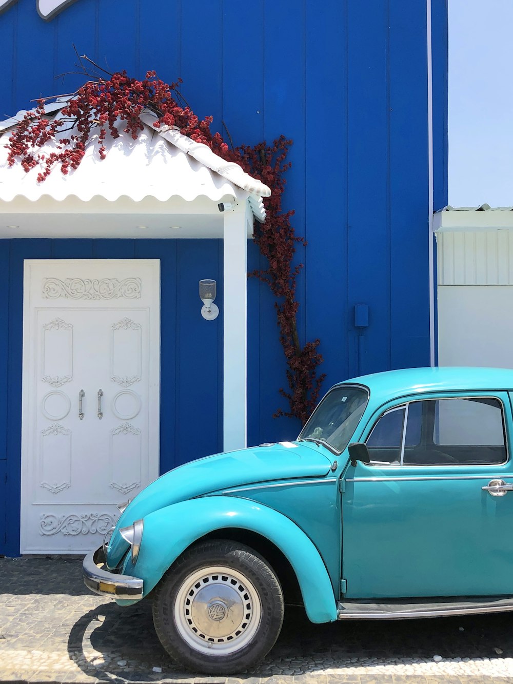 a blue car parked in front of a blue building