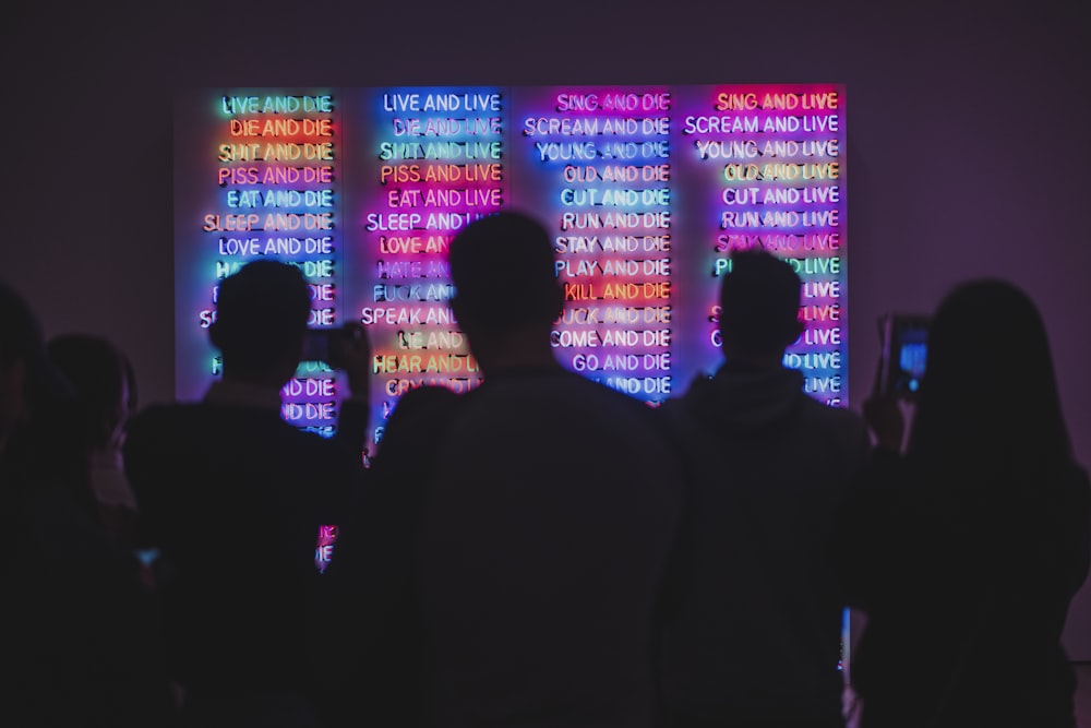 a group of people standing in front of a colorful wall