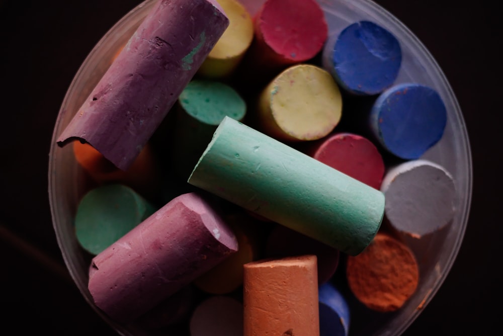 a bowl full of crayons sitting on top of a table