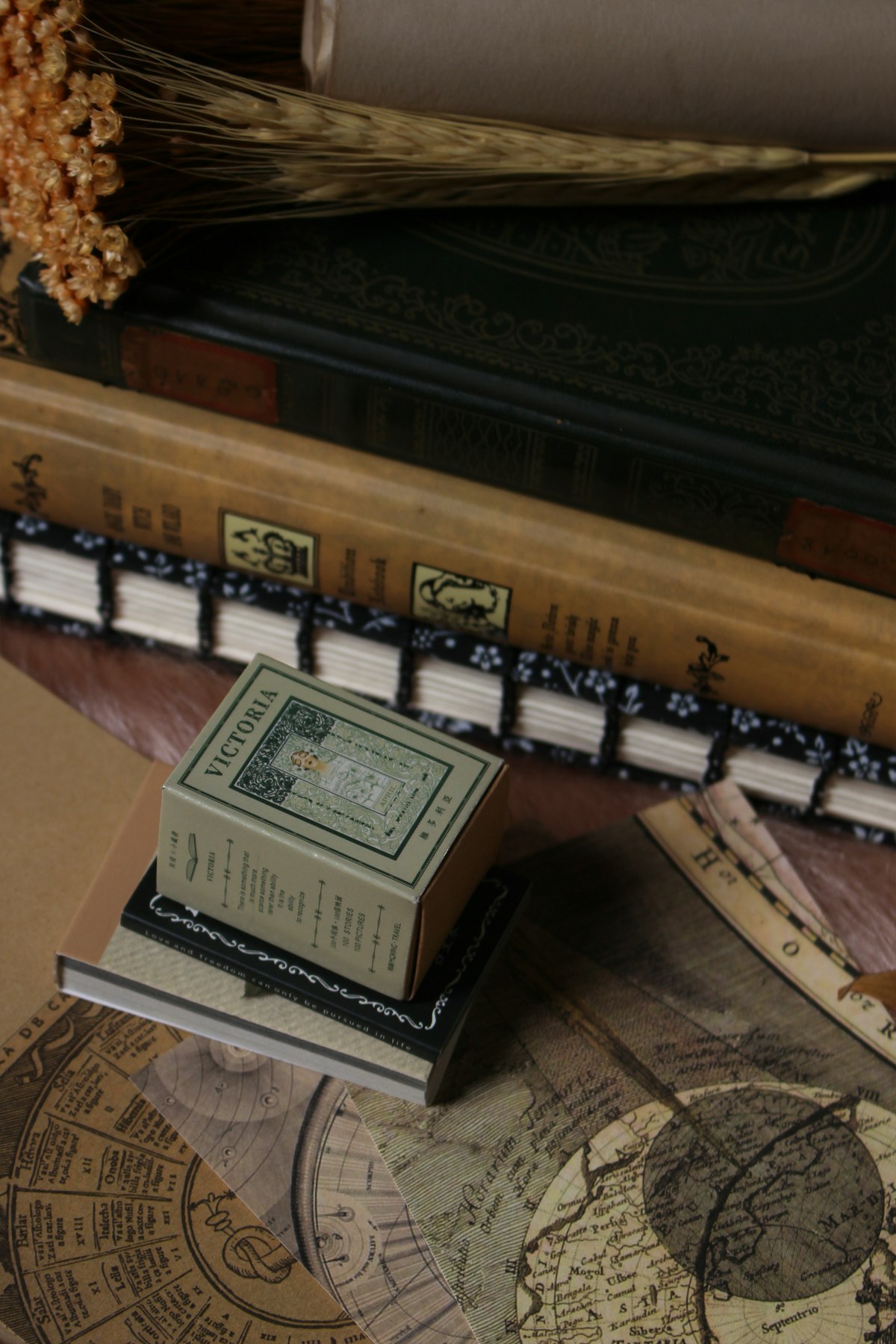 A stack of old books on a dark wooden desk, moody study atmosphere