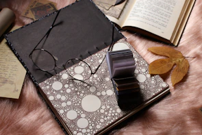 An elegant flat lay of open books with philosophical notes and a muted gold pen resting on off-white paper.