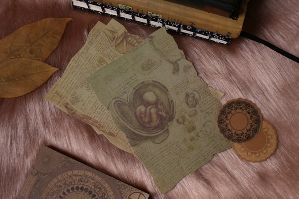 A collection of course materials and journals laid out neatly on a polished wooden table with subtle gold accents.